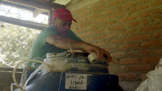 Ignacio seals a container full of NUTRI PLUS homemade fertiliser