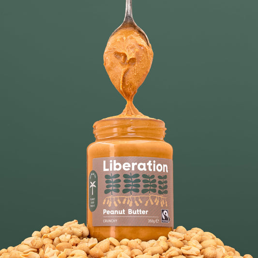 A spoonful of crunchy peanut butter coming out of a Liberation jar